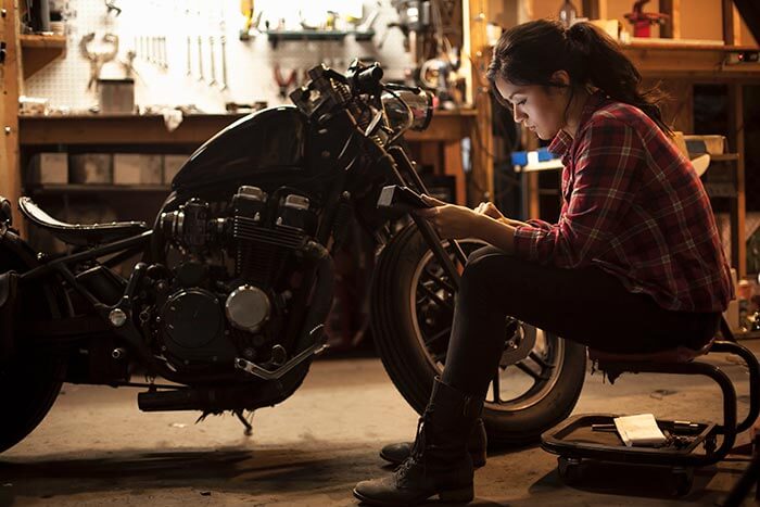 female mechanic working on motorcycle in workshop