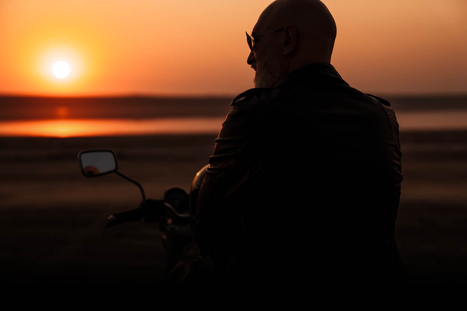 senior-man-on-motorcycle-watching-sunset