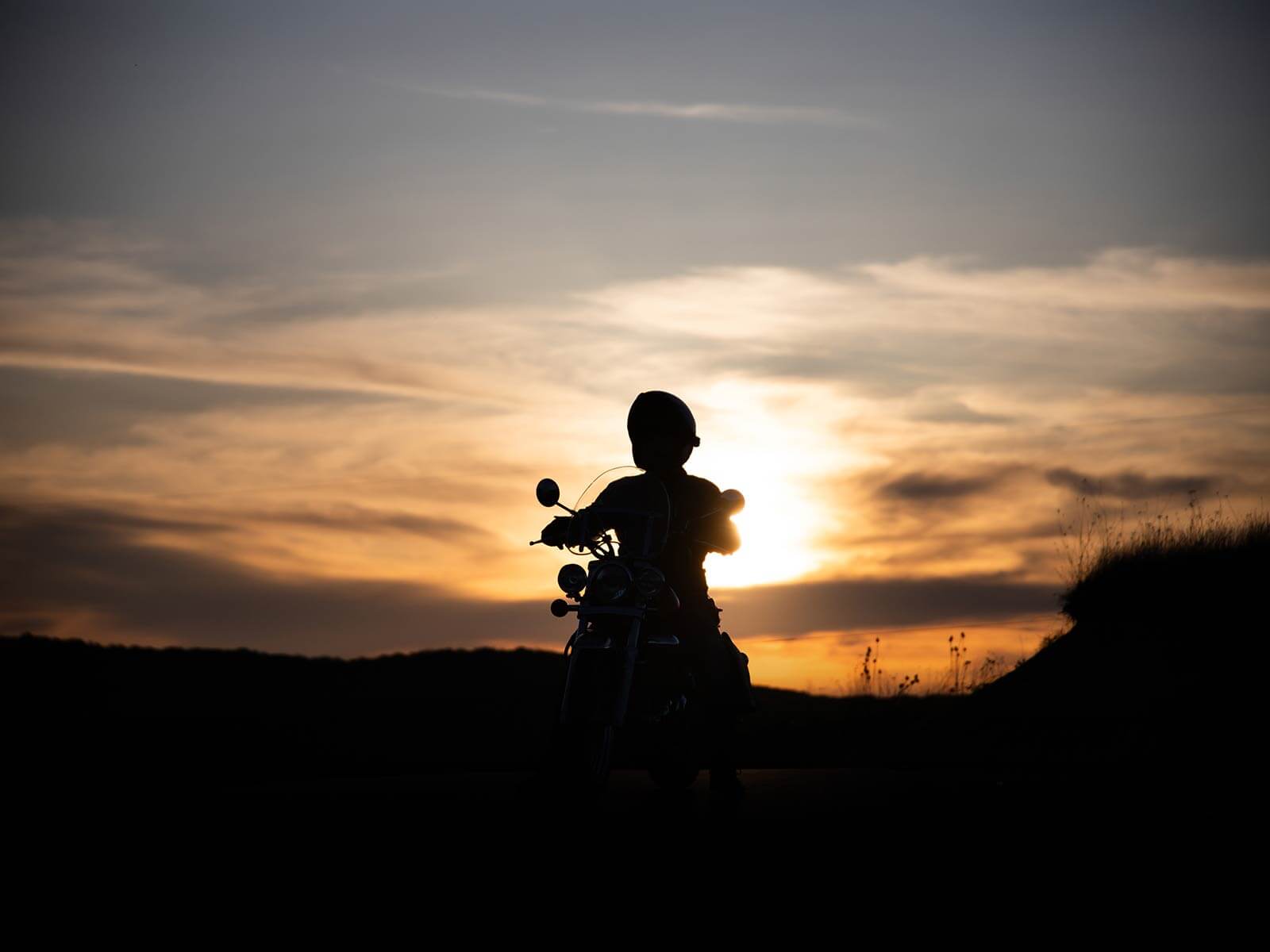 silhouette-of-rider-on-a-motorbike-admiring-sunset